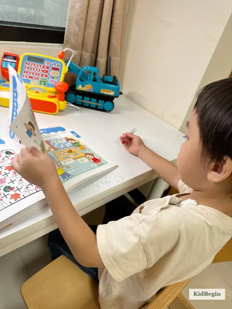孩子在桌前閱讀久保田競鍛鍊大腦遊戲書